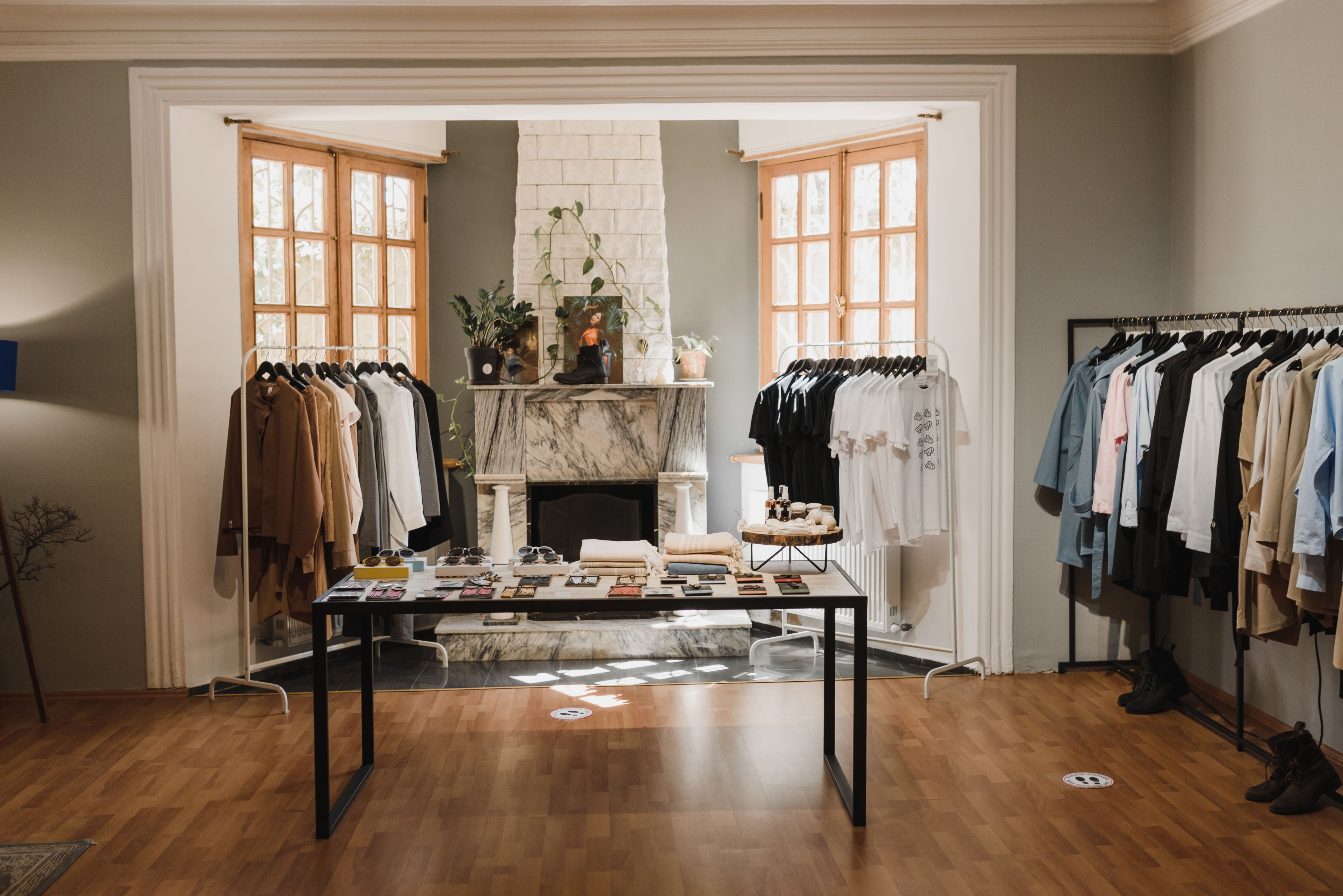 Carefully arranged luxury boutique interior with curated clothing displays, contrasting polished presentation with authenticity.